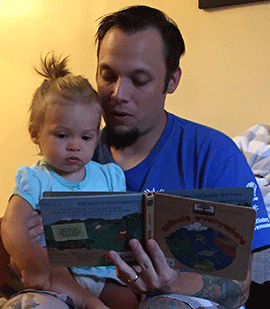 photo of William Yagatich reading to his daughter Brody