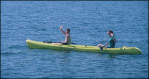 2 students enjoying the day on a green kayak