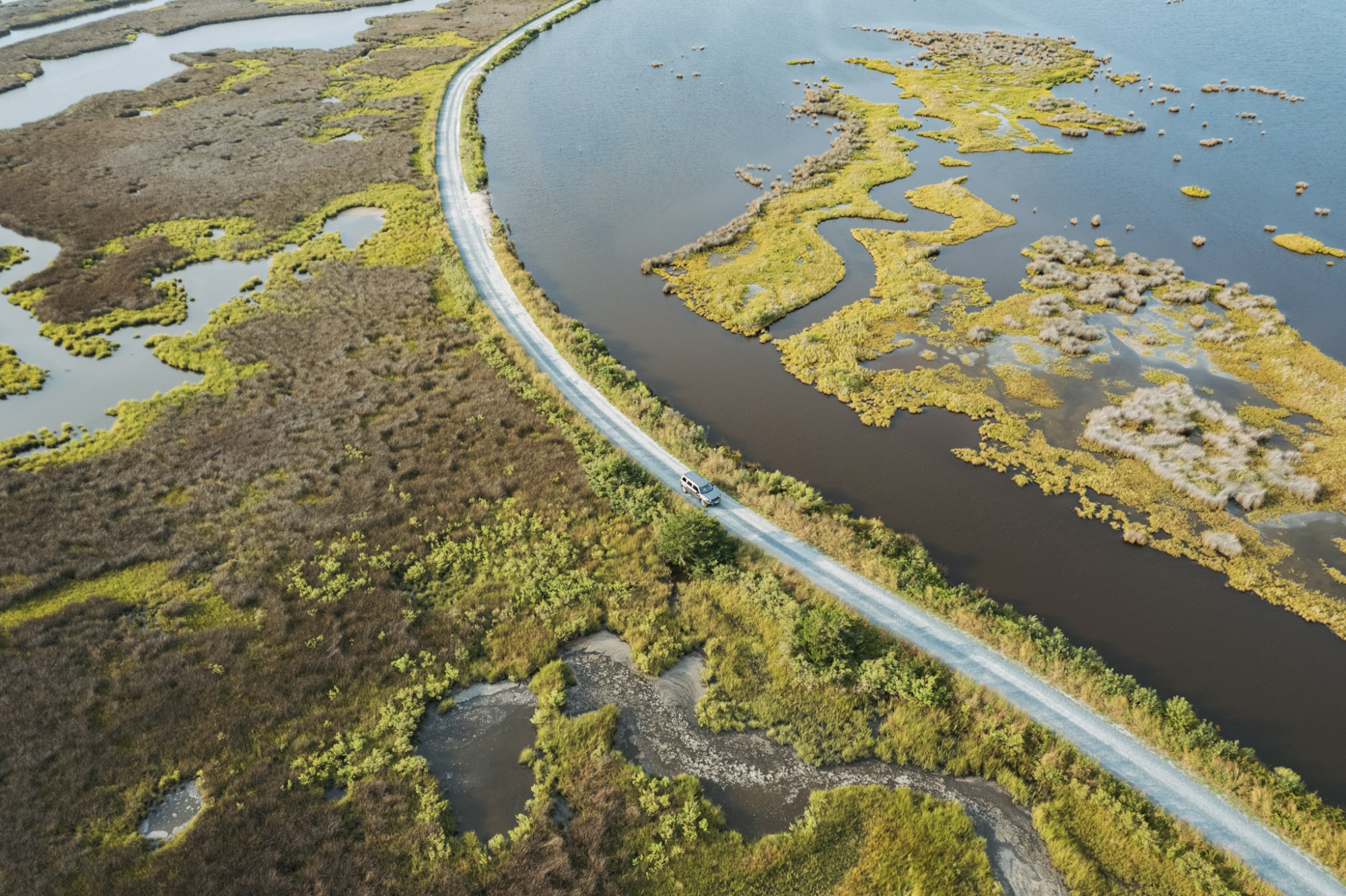 An aerial photo of a marsh with a road running through it