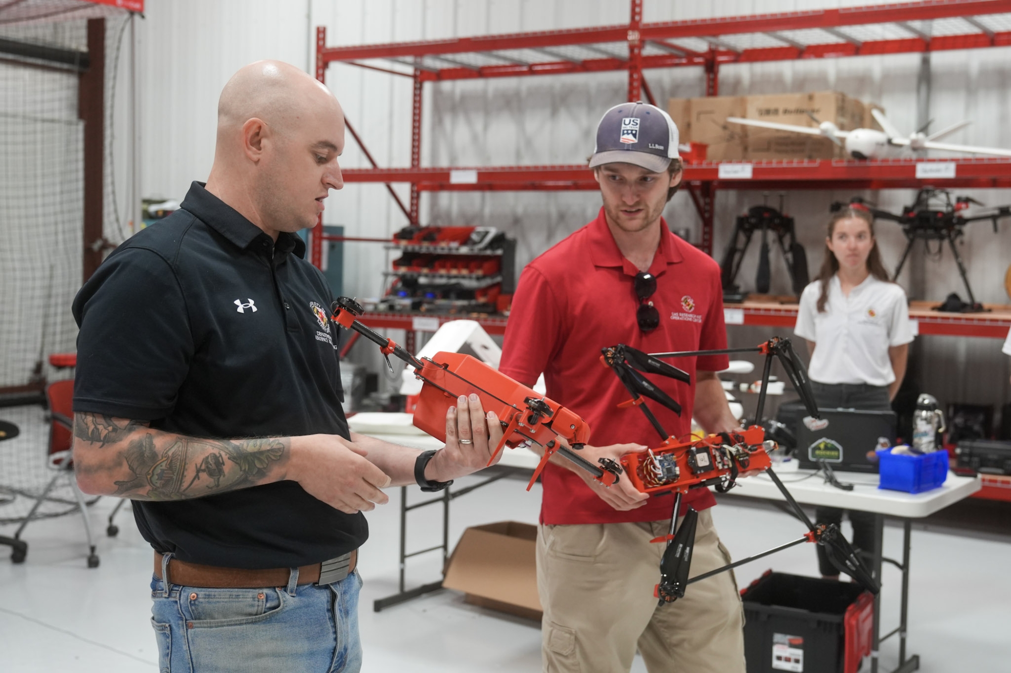 Two men hold multi-rotor drones