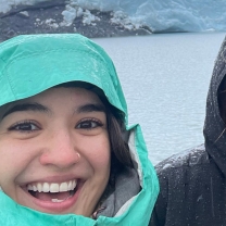 Aliya Mejias smiles in front of water and a glacier