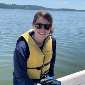 Shayna Keller wearing a yellow personal flotation device on the water's edge