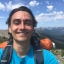 Michael Kalinowski wears a hiking backpack and poses for a selfie