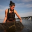 Annie moves an oyster cage while wading in a Virginia tidal river.